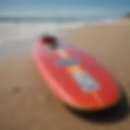 A vibrant soft longboard surfboard displayed on the beach